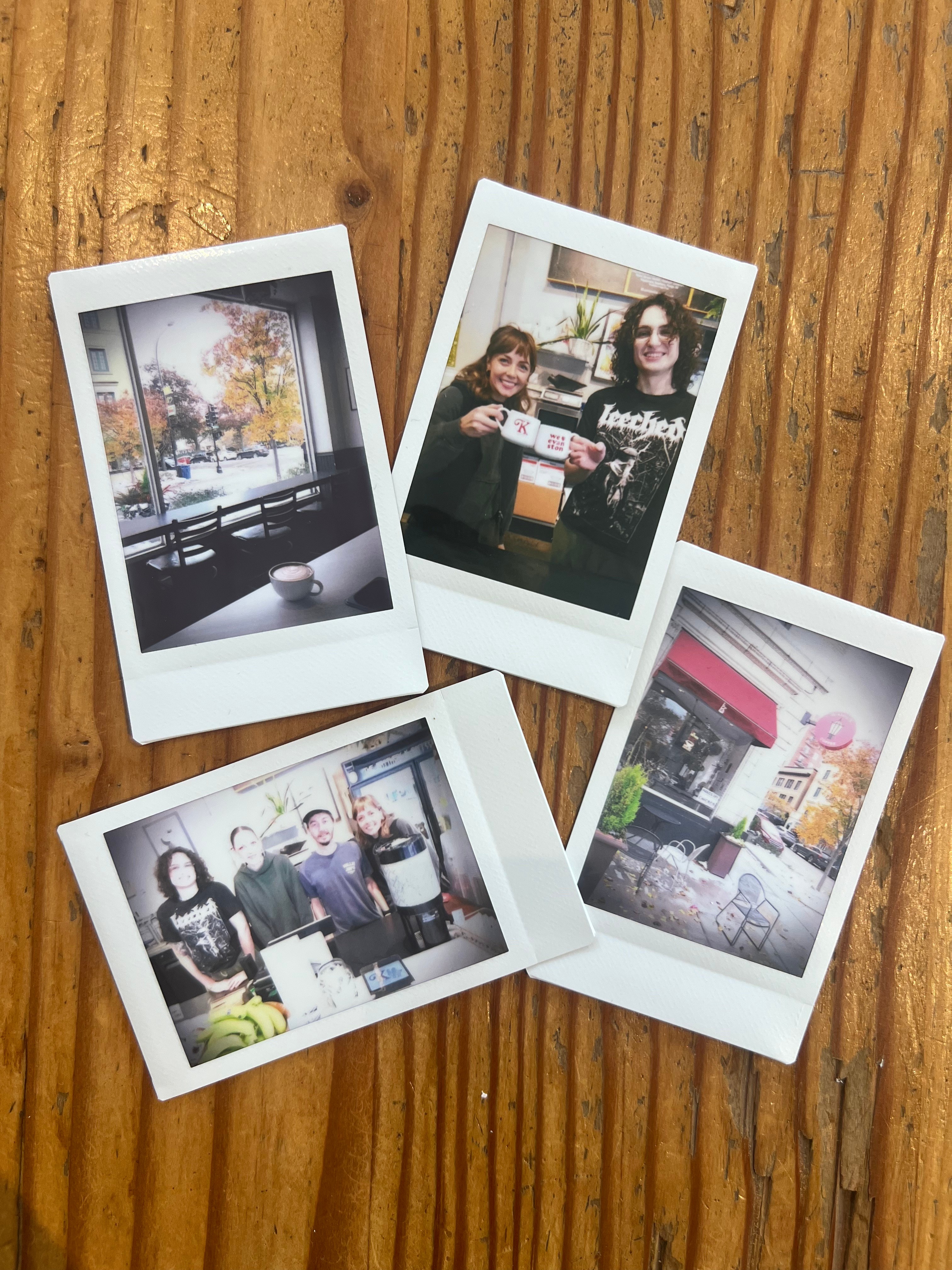 Photo of four polaroid photos on a wood surface. The polaroids show the coffeehouse