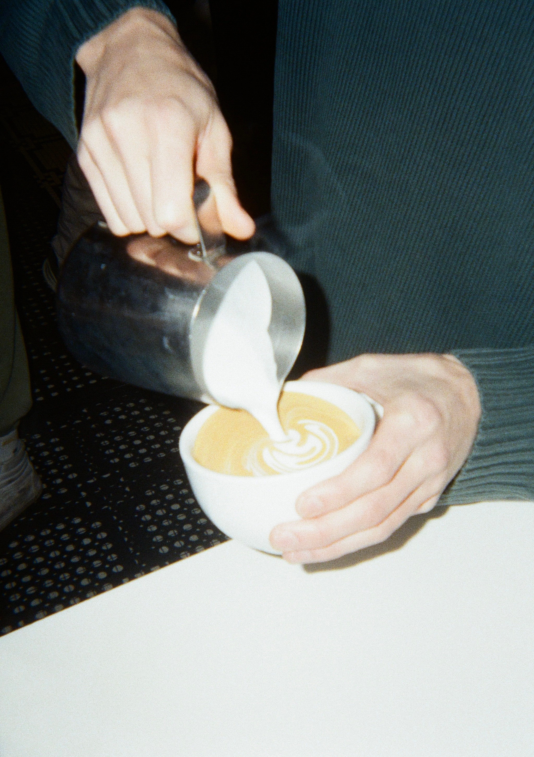 photo of barista pouring a latte